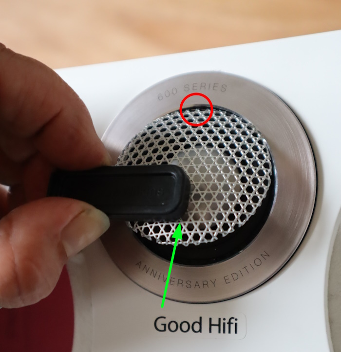 Place the magnet of the tool on the bottom of the metal grille and lift the grille so that it hinges at the top (at the red circle).