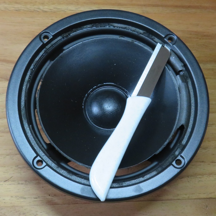 JBL A0306 woofer reparatie: verwijder de sierrand door deze met een mesje op te tillen