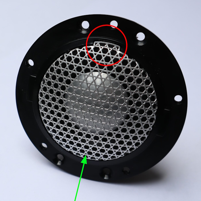 B&W tweeter met grille. Plaats de magneet van het speciale gereedschap op de plaats van de pijl. De grille klemt vast op de plaats van de cirkel.